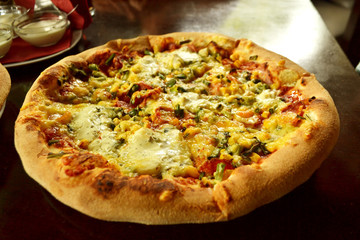 whole italian pizza on wood table with ingredients