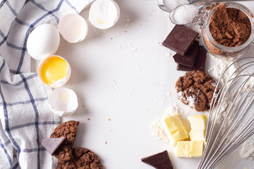 Ingredients for baking chocolate cookies on a white background close-up top view and place for text.