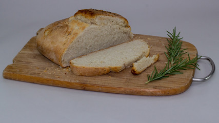 sliced rustic rosemary bread on wooden board 