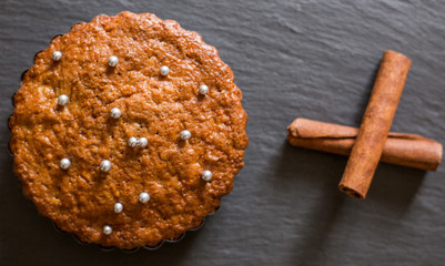 Tasty cooked cake and gift box decorated with small beads on table in kitchen