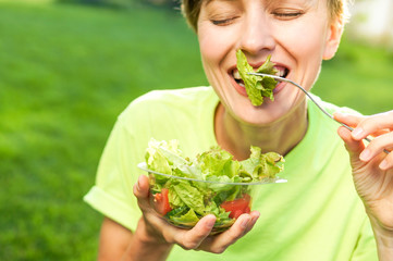 Young woman eating salad	