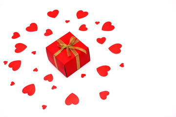 Red box with a bow of Golden ribbon. Gift and Hearts of red paper. Holiday and love concept. Valentine's day