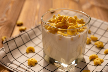 cup of milk with cereal rings in a sunny morning as healthy breakfast