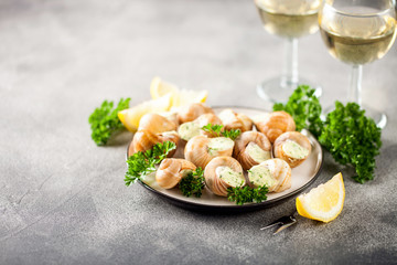 Escargots de Bourgogne - Snails with herbs butter on gray background. Selective focus