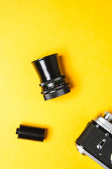 Old camera and lens on yellow background