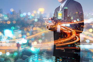 Double Exposure, Businessman use Mobile Smartphone device with Night City Building