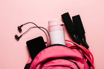 Sports bag and accessories on pink background