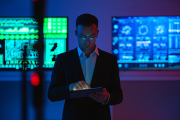 The businessman with a tablet standing on screens background