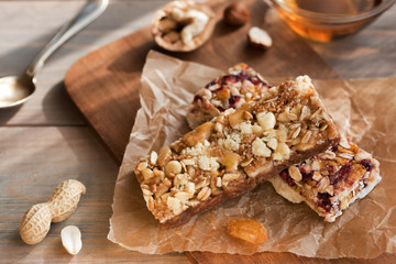 Granola bars with nuts and dried fruits and honey on wooden background- snack for healthy still live