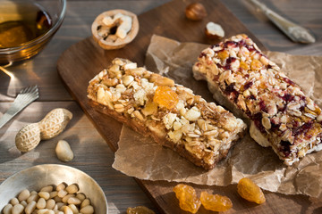 Granola bars with nuts and dried fruits and honey on wooden background- snack for healthy still live