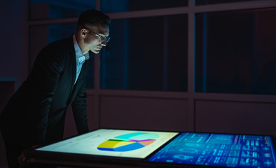 The businessman working with big screens in the dark room