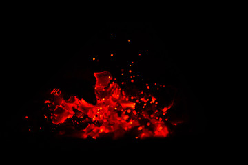Hot wooden coals in the dark. Grill with hot coals and beautiful magic sparks with blue flame