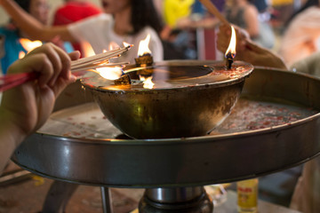 hand cense joss stick to at an incense burne