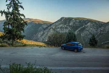 economy blue car stop on side of road on mountain highland scenery landscape in evening twilight before sunset