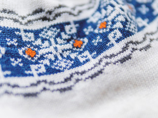 Knitted nordic pattern with blue snowflakes. Fabric with traditional scndinavian ornament. Warm outerwear.
