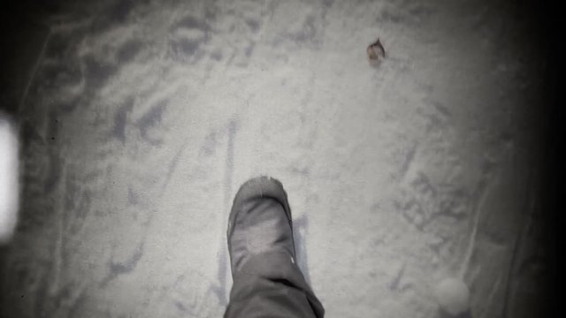 Fake 8mm film projection: detail show of people wearing ski, walking in the fresh white snow.