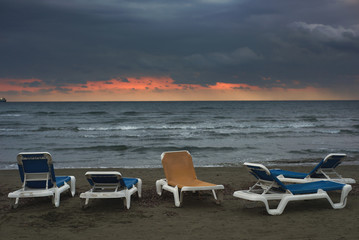 Blue and yellow sun loungers on the background of the sea at sunset. Landscape. Shooting in daylight. Author's retouch