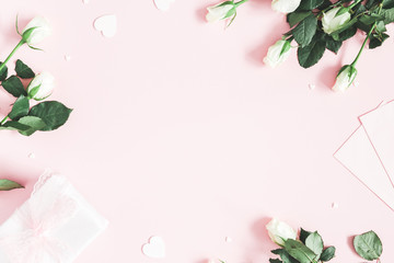 Valentine's Day composition. Gift box, white rose flowers, envelope on pastel pink background. Valentine's day, Mother's day concept. Flat lay, top view, copy space