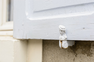 Top of a wooden shutter with a woman's head