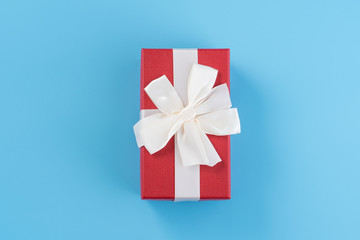 Red gift box with white ribbon bow, concept of giving present and Valentine's, anniversary, mother's day and birthday surprise, copy space, top view