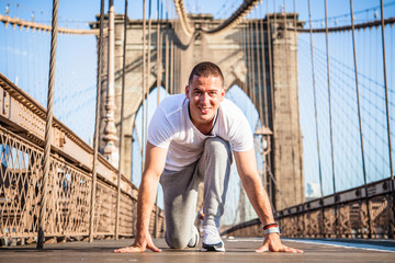 Young athlete sprinter preparing to start a race on Brooklyn Bridge in New York City