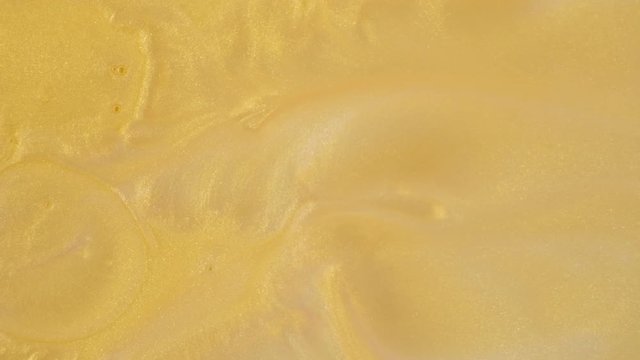 Colorful golden sand organically moves in colorful liquid