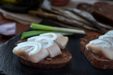 Sliced herring on rye bread with onion.