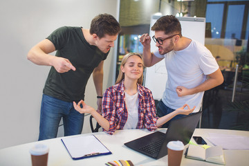 Two angry young men stand upon blonde model and point on her. They scream. Three people are in one...