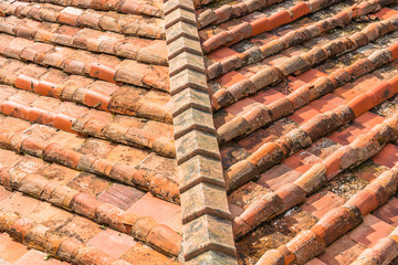 Ceramic orange clay tiles on the roof of a building, corner.