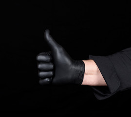 male chef's hand in black latex gloves  shows a gesture of approval