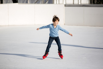 Fototapeta na wymiar Happy boy with hat and jacket, skating during the day, having fun .