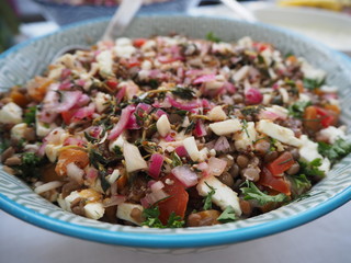 A buffet table with an assortment of different salads, with party decor, Pasta salad, potato salad, bean salad and fresh mixed salad.