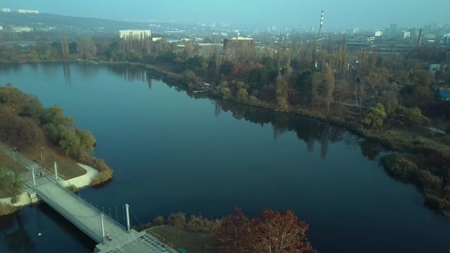 Aerial footage over Echo Park Lake, Kishinev, Moldova republic of. View of lake and smille bridge.