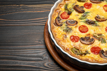 Baked homemade quiche pie in ceramic baking form