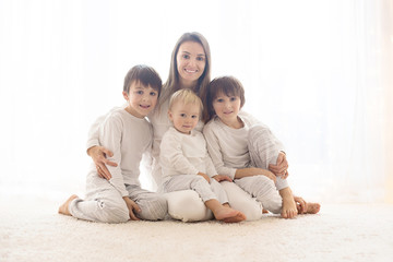 Family portrait of mother and her three boys, isolated on white, back light
