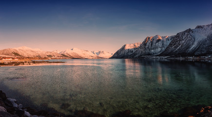Beautiful winter sunset landscape, panorama of the lake with snowy mountains with blue sky, natural travel outdoor background, Lofoten Islands, Northern Norway