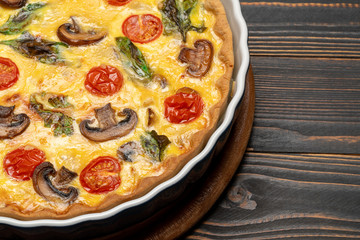 Baked homemade quiche pie in ceramic baking form