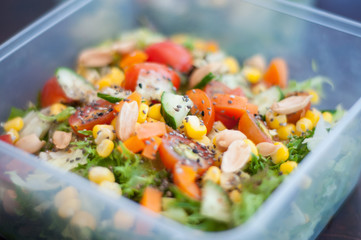 Close up of fresh and healthy salad made with fruits and vegetables in a container.