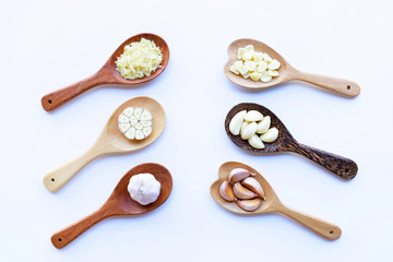 Garlic on wooden spoon on white