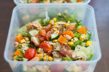 Close up of fresh and healthy salad made with fruits and vegetables in a container.