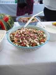 A buffet table with an assortment of different salads, with party decor, Pasta salad, potato salad, bean salad and fresh mixed salad.