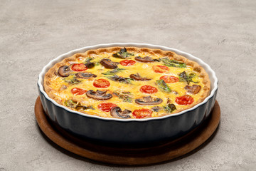Baked homemade quiche pie in ceramic baking form