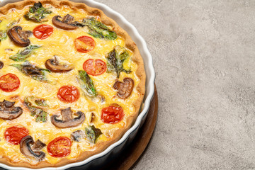 Baked homemade quiche pie in ceramic baking form