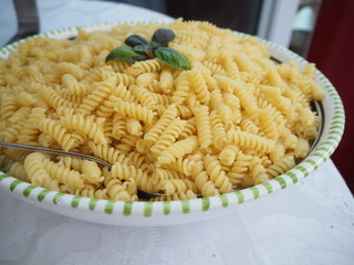 Bowl of pasta decorated with herbs close up