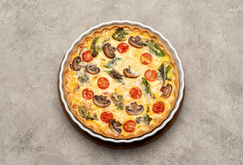 Baked homemade quiche pie in ceramic baking form