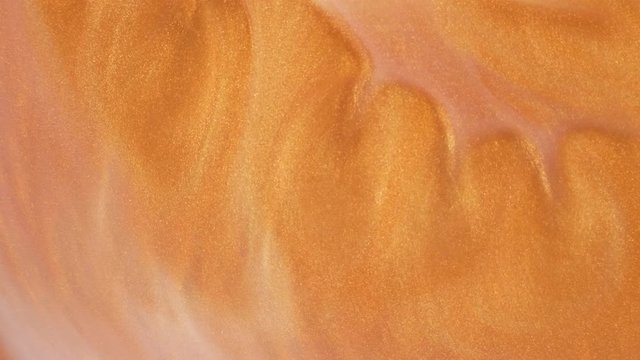 Colorful golden sand organically moves in colorful liquid