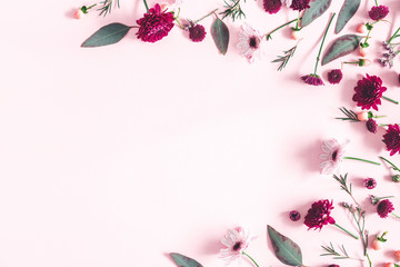 Flowers composition. Eucalyptus leaves and pink flowers on pastel pink background. Flat lay, top view, copy space