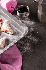 Baking tray with fresh biscuits, sprinkled with powdered sugar