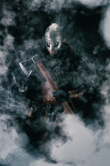 Portrait of a Viking holding an ax in the mist
