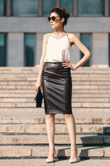 Fashionable brunette businesswoman in leather pencil skirt and s